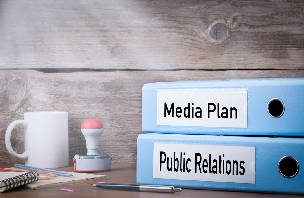 Public Relations and Media Plan. Two binders on desk in the office. Business background